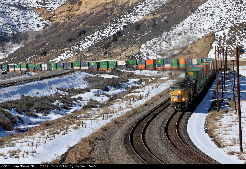 UP 8664, 9021, 7781 (SD70ACE, SD70ACE, C45ACCTE) lead an eastbound stack train approaching the Echo Rd. OHB in Emory, Utah. February 19, 2022 {Winter Echofest}